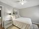 A cozy bedroom featuring wood floors, a ceiling fan and a bright window at 2026 Knell Dr, Charlotte, NC 28212