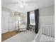 Bedroom showcases white crib, board and batten accent wall and neutral color palette at 2026 Knell Dr, Charlotte, NC 28212