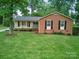 Charming brick home with manicured lawn, inviting entrance and mature trees at 2026 Knell Dr, Charlotte, NC 28212