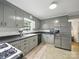 Functional kitchen featuring gray cabinets, stainless steel refrigerator and dishwasher, and tile flooring at 2026 Knell Dr, Charlotte, NC 28212