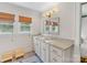 Well-lit bathroom featuring a dual sink vanity, granite countertops, and two windows at 2112 Chatham Ave, Charlotte, NC 28205