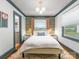 Stylish bedroom with patterned wallpaper, complemented by natural light from two windows at 2112 Chatham Ave, Charlotte, NC 28205