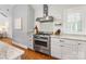 Modern kitchen with stainless steel range hood, granite countertops, and white cabinetry at 2112 Chatham Ave, Charlotte, NC 28205