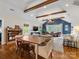 Open-concept living and dining area with exposed beams, wood floors, and comfortable furnishings at 2112 Chatham Ave, Charlotte, NC 28205