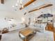 Open-concept living room with exposed beams, modern lighting, and seamless flow to the kitchen at 2112 Chatham Ave, Charlotte, NC 28205