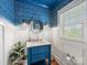 Charming powder room boasts blue vanity, round mirror, and statement wallpaper for a stylish, unique touch at 2112 Chatham Ave, Charlotte, NC 28205