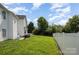 Back view of home showcasing expansive, grassy backyard with privacy fence at 220 Otman Ct, Rock Hill, SC 29732