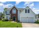 Charming home featuring a two-car garage, brick accents, a well-manicured lawn and inviting curb appeal at 220 Otman Ct, Rock Hill, SC 29732
