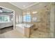 Bathroom showing bathtub, glass enclosed shower with bench, tiled shower walls and a view into a bedroom at 2213 Hartwell Ln # 84, Indian Land, SC 29707