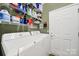 Laundry room features organized shelving with cleaning supplies, a washer, dryer, and a white door at 2213 Hartwell Ln # 84, Indian Land, SC 29707