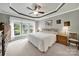 Tranquil main bedroom with tray ceiling, ceiling fan, carpet, and large windows overlooking the landscaped yard at 2213 Hartwell Ln # 84, Indian Land, SC 29707