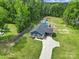 Expansive aerial view showcasing a single-story home, a private pool, and lush greenery in a serene setting at 2302 Douglas Rd, Lancaster, SC 29720