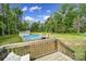 Backyard featuring an above ground pool surrounded by trees and a deck at 2302 Douglas Rd, Lancaster, SC 29720