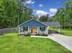 Charming single-story home with a welcoming front porch and rocking chairs, complemented by lush greenery at 2302 Douglas Rd, Lancaster, SC 29720