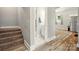Hallway with stairs leading to upper floor and access to bathroom with bright light at 238 N Depot St, Albemarle, NC 28001
