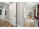 Bright hallway with hardwood flooring leading to a kitchen with stainless steel appliances at 238 N Depot St, Albemarle, NC 28001