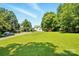View of large yard with mature trees, landscaping and a shed, enhancing the property's appeal at 238 N Depot St, Albemarle, NC 28001