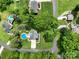 Aerial view of the property showcasing the home, mature trees, in-ground pool, and surrounding landscape at 240 Hillcrest Dr, Harrisburg, NC 28075