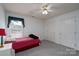 Cozy bedroom with a plaid bedspread, ceiling fan, and window at 240 Hillcrest Dr, Harrisburg, NC 28075
