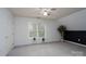 Bonus room featuring a black accent wall, ceiling fan, and natural light at 240 Hillcrest Dr, Harrisburg, NC 28075