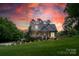 Charming home featuring a landscaped yard, inviting front porch, and patriotic American flag at 240 Hillcrest Dr, Harrisburg, NC 28075