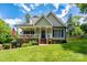 Charming two-story home with a welcoming front porch, blue shutters and door, and beautifully landscaped yard at 240 Hillcrest Dr, Harrisburg, NC 28075