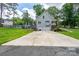 View of the back of the house with a two-car garage, a deck, and well-maintained landscaping at 240 Hillcrest Dr, Harrisburg, NC 28075
