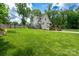 Spacious backyard featuring an above-ground pool, a deck, a lush lawn, and mature trees at 240 Hillcrest Dr, Harrisburg, NC 28075