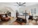 Bedroom with a decorative rug, four-poster bed, ceiling fan, and desk area, creating a functional and stylish space at 266 Riverwood Rd, Mooresville, NC 28117