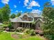 Charming brick home featuring mature trees and beautiful landscaping creating a welcoming curb appeal at 266 Riverwood Rd, Mooresville, NC 28117