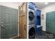 Mud room with stacked laundry machines, storage cabinets, and a bench seating area at 266 Riverwood Rd, Mooresville, NC 28117