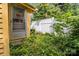 Exterior shot of yellow house with overgrown plants in the backyard near a white fence at 310 S Spencer Ave, Spencer, NC 28159
