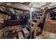 Unfinished basement with brick walls, wooden staircase, exposed pipes, and support beams at 310 S Spencer Ave, Spencer, NC 28159