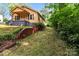 Cozy yellow home with a brick foundation and retaining wall, lush lawn and mature trees at 310 S Spencer Ave, Spencer, NC 28159