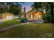 Charming yellow home featuring a detached garage, blooming hydrangeas, and inviting front porch at 310 S Spencer Ave, Spencer, NC 28159