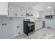 Bright kitchen featuring white cabinets, stainless steel appliances, and modern tile flooring at 310 S Spencer Ave, Spencer, NC 28159