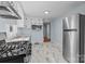 Bright kitchen with stainless steel appliances, white cabinets, and marble-look tile flooring at 310 S Spencer Ave, Spencer, NC 28159
