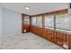 Light-filled sunroom featuring knotty pine walls, marble floors, and multiple windows at 310 S Spencer Ave, Spencer, NC 28159