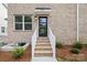 Inviting brick entrance with a modern black door, enhanced by stylish lighting and well-maintained landscaping at 3932 Hager Dr, Charlotte, NC 28208