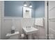 Stylish bathroom with white wainscoting, pedestal sink, and medicine cabinet at 409 S Grove St, Lincolnton, NC 28092
