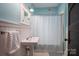 Charming bathroom with pedestal sink and a shower with a blue patterned curtain at 409 S Grove St, Lincolnton, NC 28092