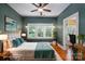 Bright bedroom boasts hardwood floors, ceiling fan, and triple window with view of mature trees at 409 S Grove St, Lincolnton, NC 28092