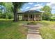 Charming blue home featuring a stone porch with beautiful front yard flowers and landscaped pathway at 409 S Grove St, Lincolnton, NC 28092