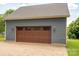 A detached two-car garage features a stylish wood door and exterior lighting at 409 S Grove St, Lincolnton, NC 28092