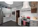 Bright kitchen features stainless steel appliances, gray cabinets and counters, white backsplash, and view to dining room at 409 S Grove St, Lincolnton, NC 28092
