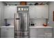 Bright kitchen showcases stainless steel refrigerator, white cabinets and counters, and multiple shelves for storage at 409 S Grove St, Lincolnton, NC 28092