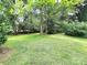 Lush backyard featuring mature trees and green grass, offering a serene outdoor space at 423 N Cedar St, Lincolnton, NC 28092