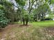 Lush backyard featuring mature trees and well-maintained grassy areas, offering serene outdoor space at 423 N Cedar St, Lincolnton, NC 28092