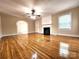 Spacious living room with gleaming hardwood floors, fireplace, ceiling fan, and lots of natural light at 423 N Cedar St, Lincolnton, NC 28092