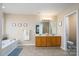 Well-lit bathroom with double vanity, tub, tile floors, and framed art at 4915 Juniper Grove Sw Ct, Concord, NC 28027
